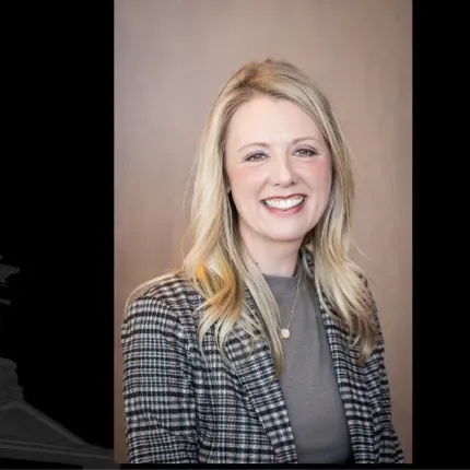 Portrait of Leah Wong, CMO, smiling with long blonde hair in a checkered blazer
