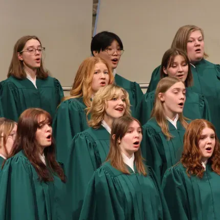 The Lucia Singers performing in their traditional green choir robes.