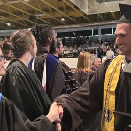 Commencement2025 graduate shaking hands