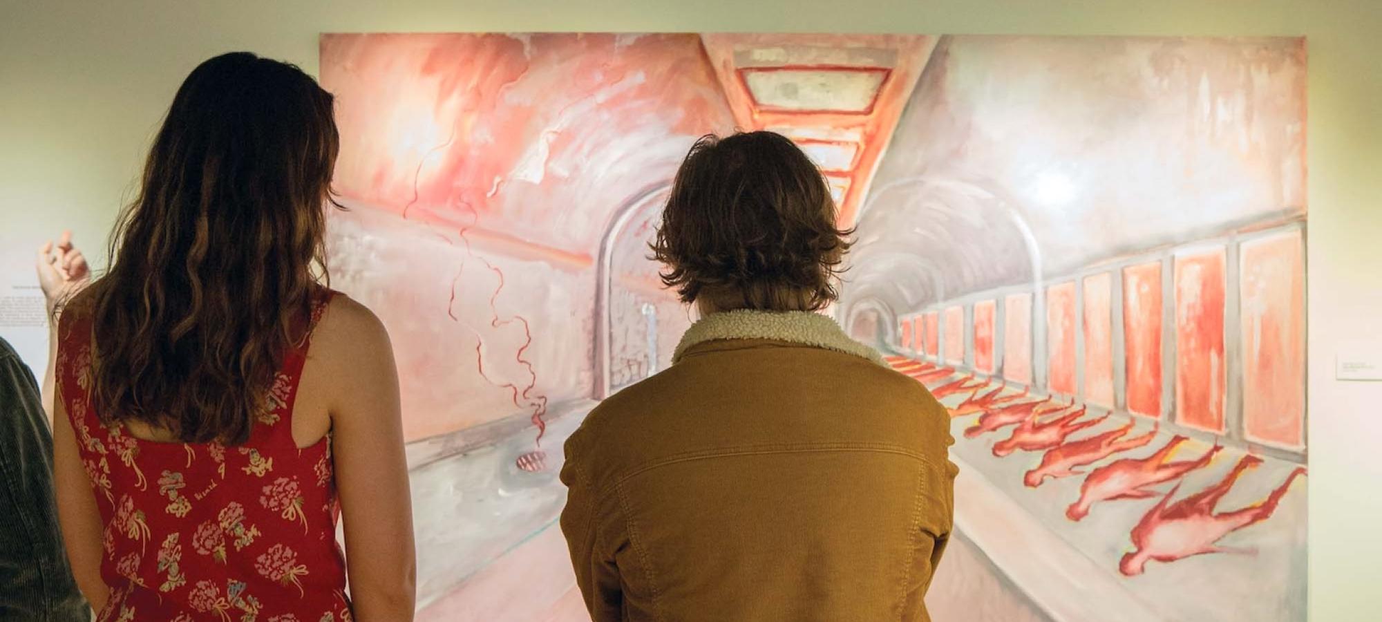 Two students at Gustavus Adolphus College consider a painting. 