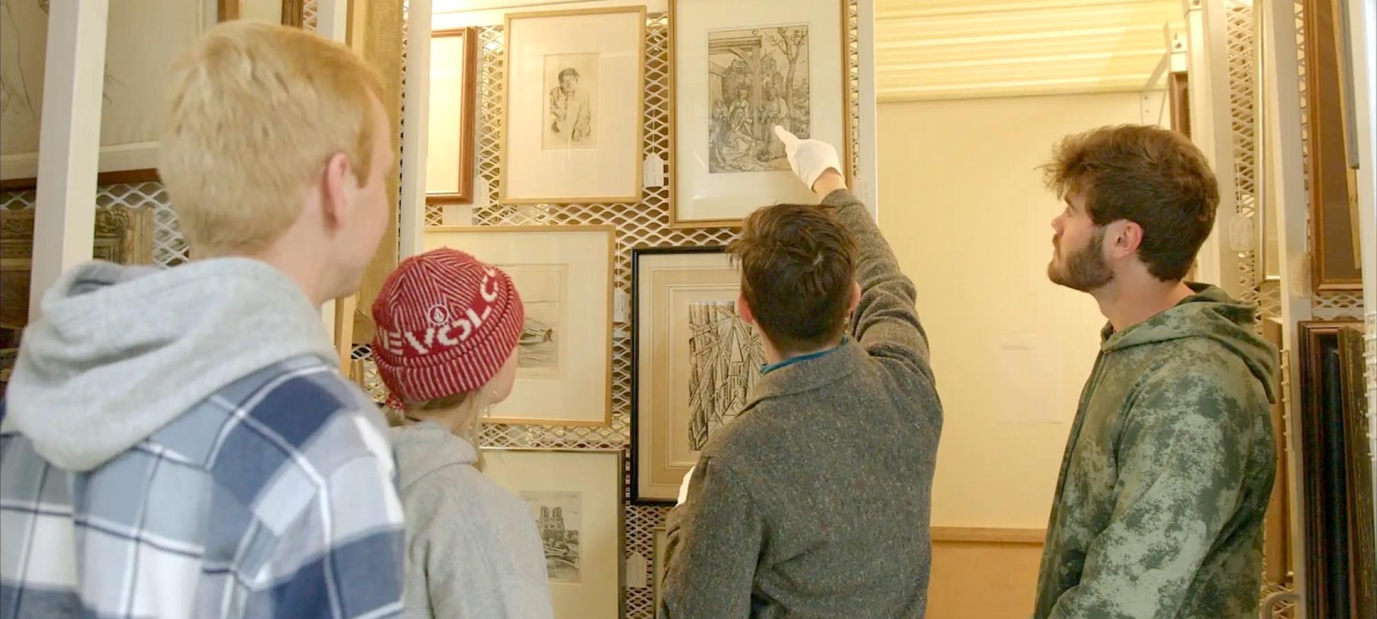 A professor shows Gustavus students an aspect of a painting. 