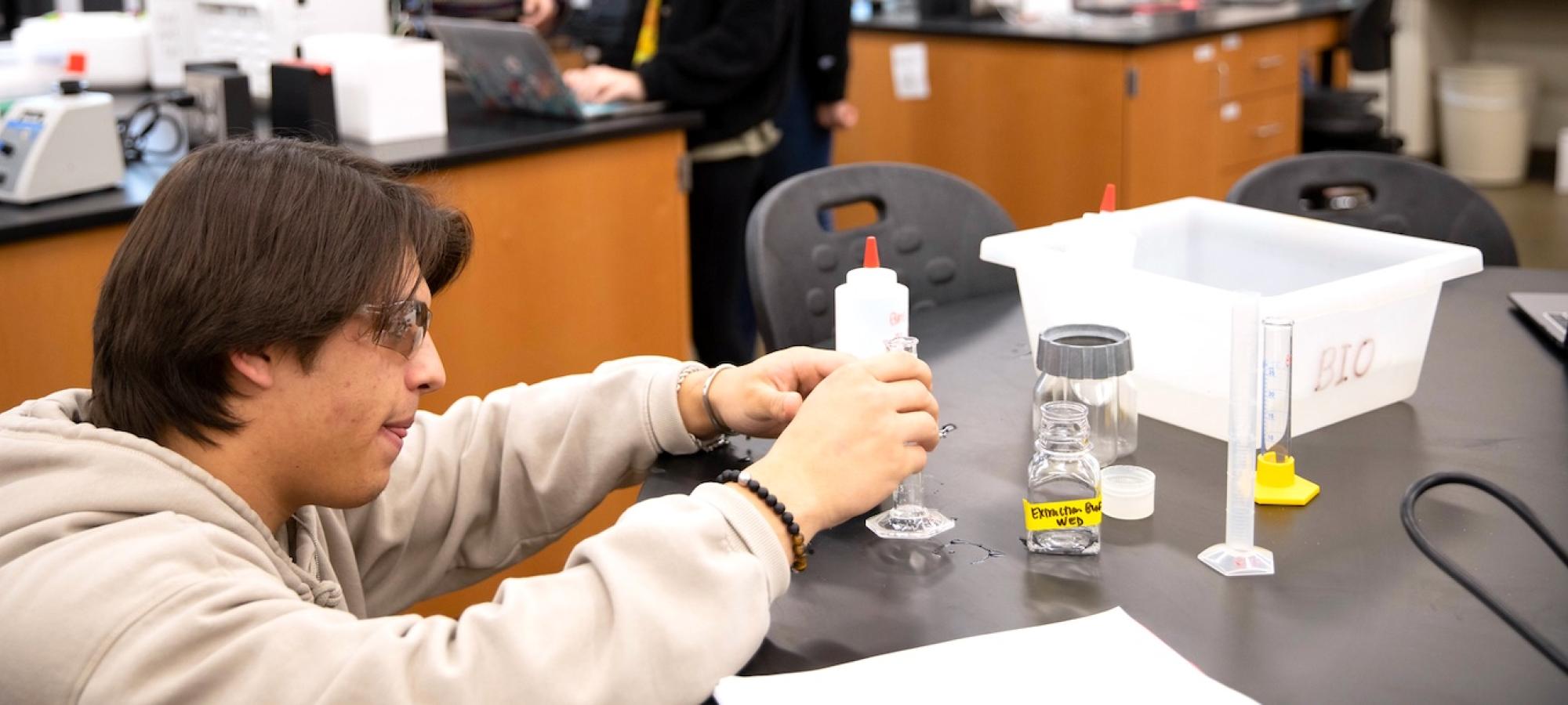 A student in the sciences measures a liquid. 