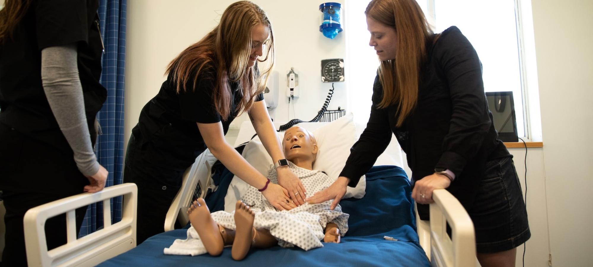 Nurses and a nursing instructor around a patient. 