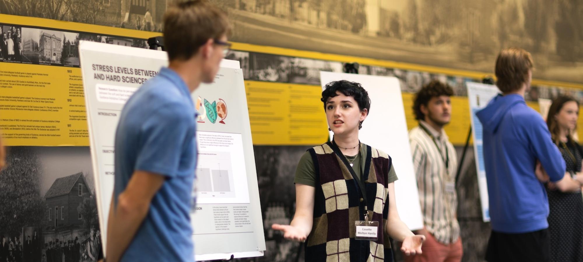 A student explains her research to another student. 
