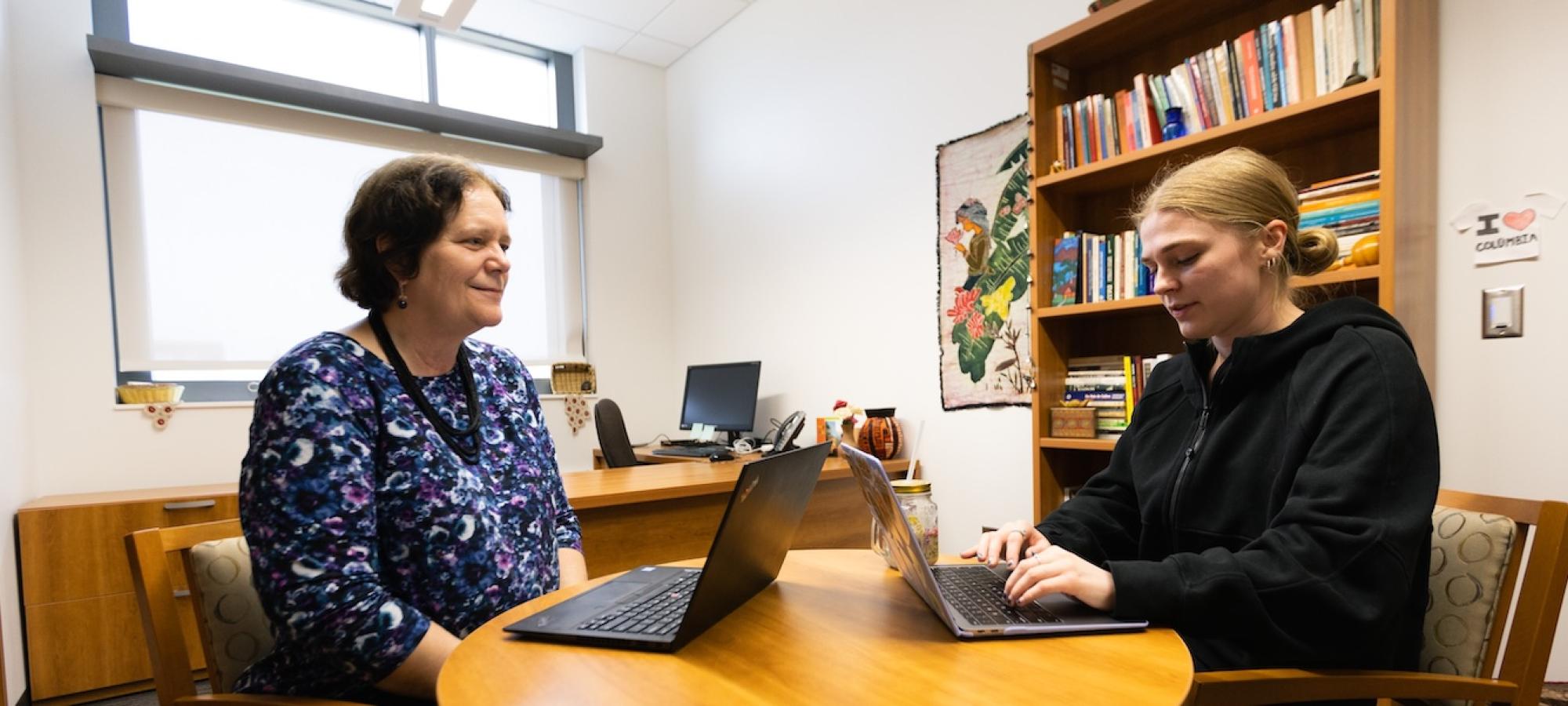 A student and a professor talk in an office. 