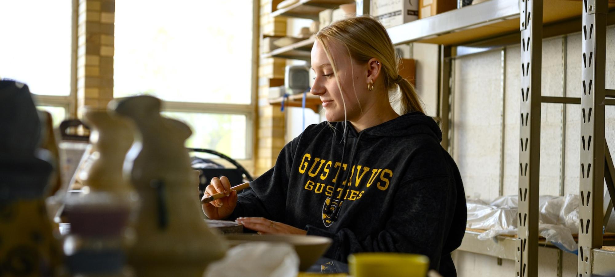 A Gustavus Adolphus College student works in the pottery studio. 