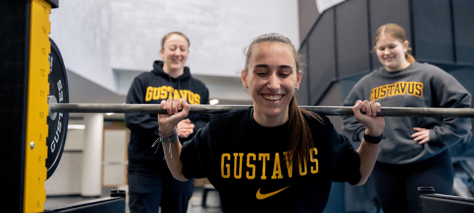 Women lifing weights with athletic trainer