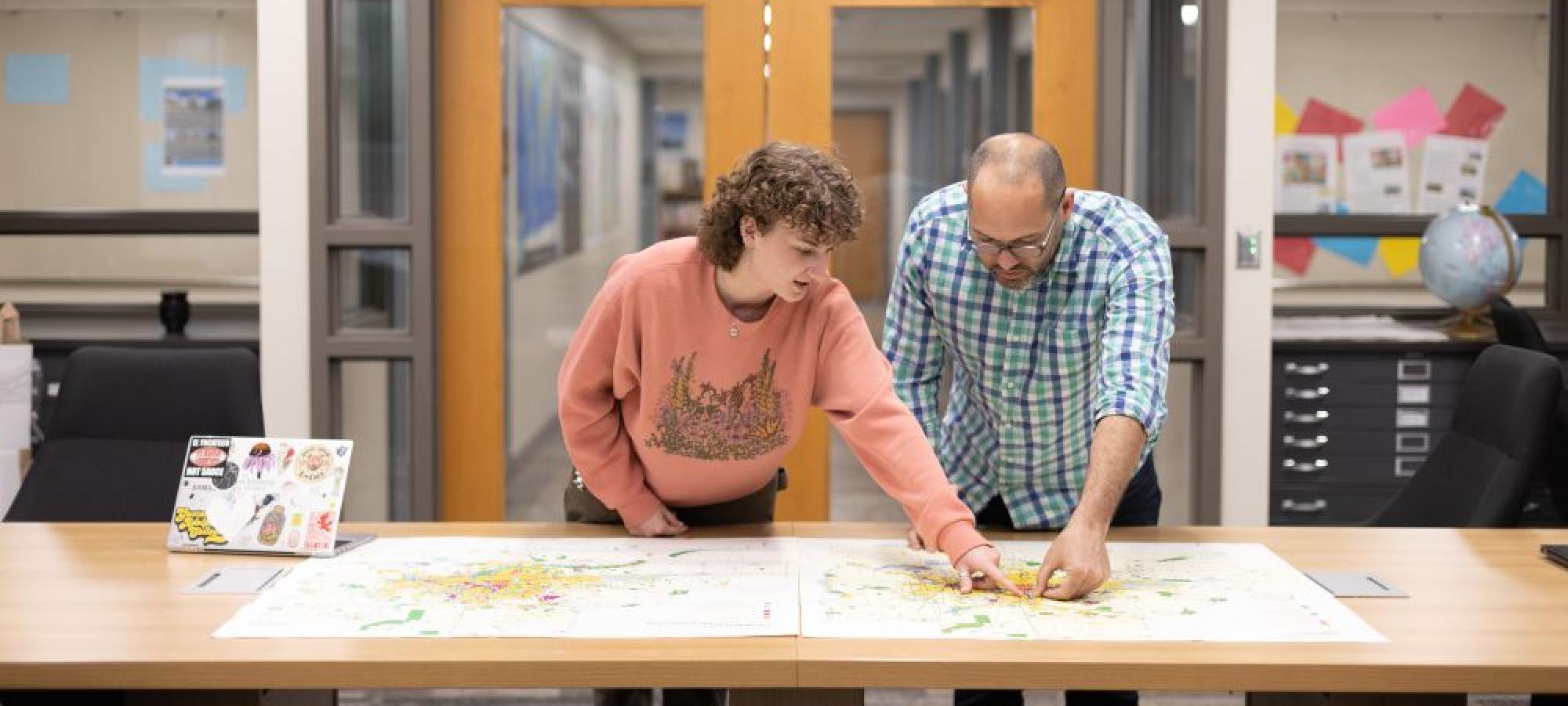 Geography student and faculty in map room
