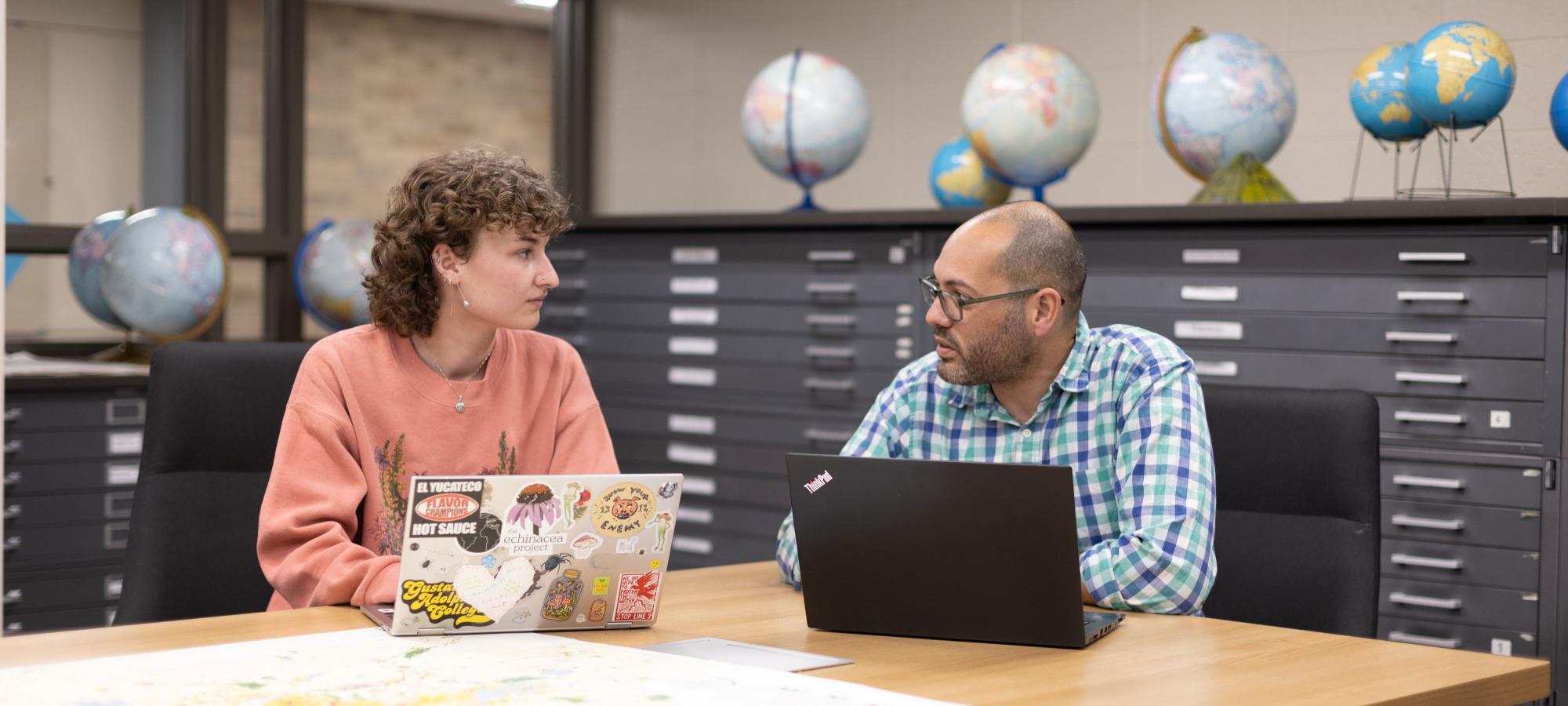 Geography student and faculty in map room