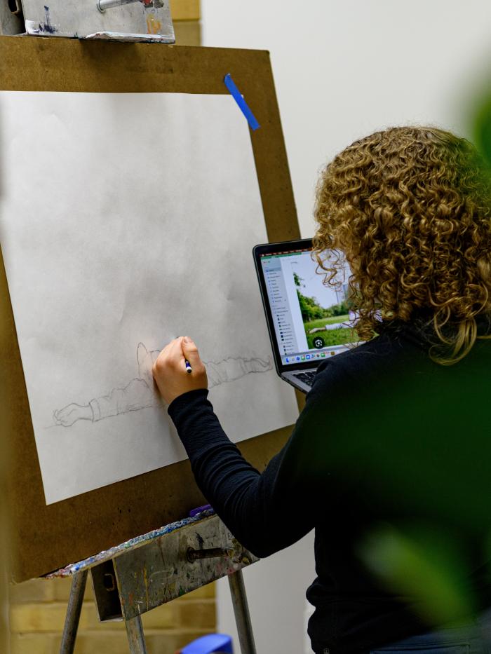 Drawing student in art building