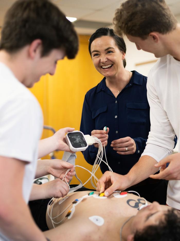 Facult and students practicing monitoring vitals