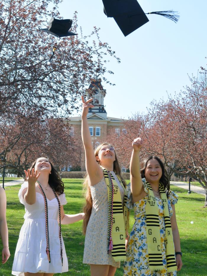 Old main graduates tossing hats