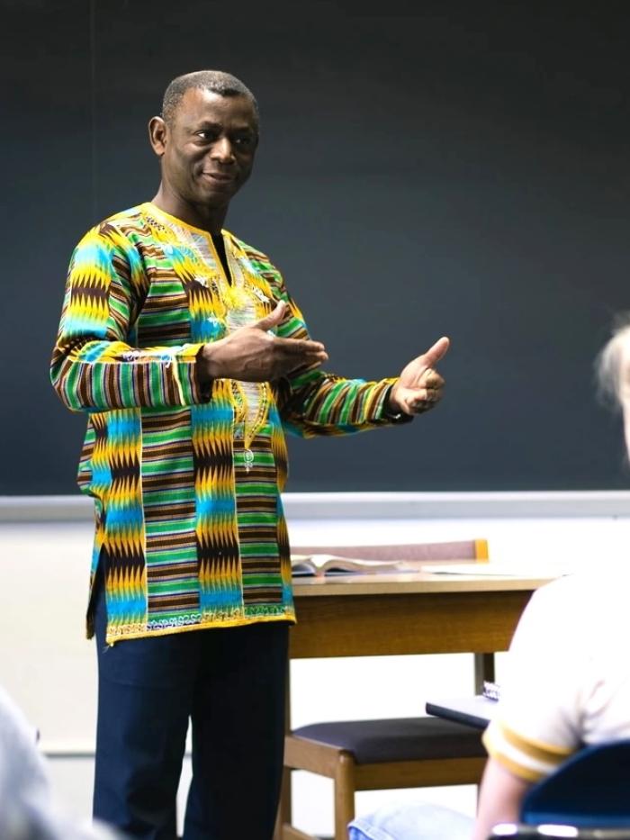 A professor of African Studies gestures to a student in a classroom. 