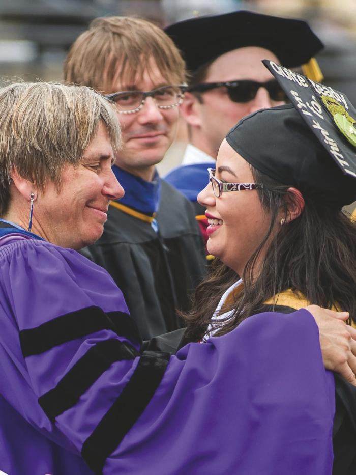 A philosophy professor hugs a philosophy student.