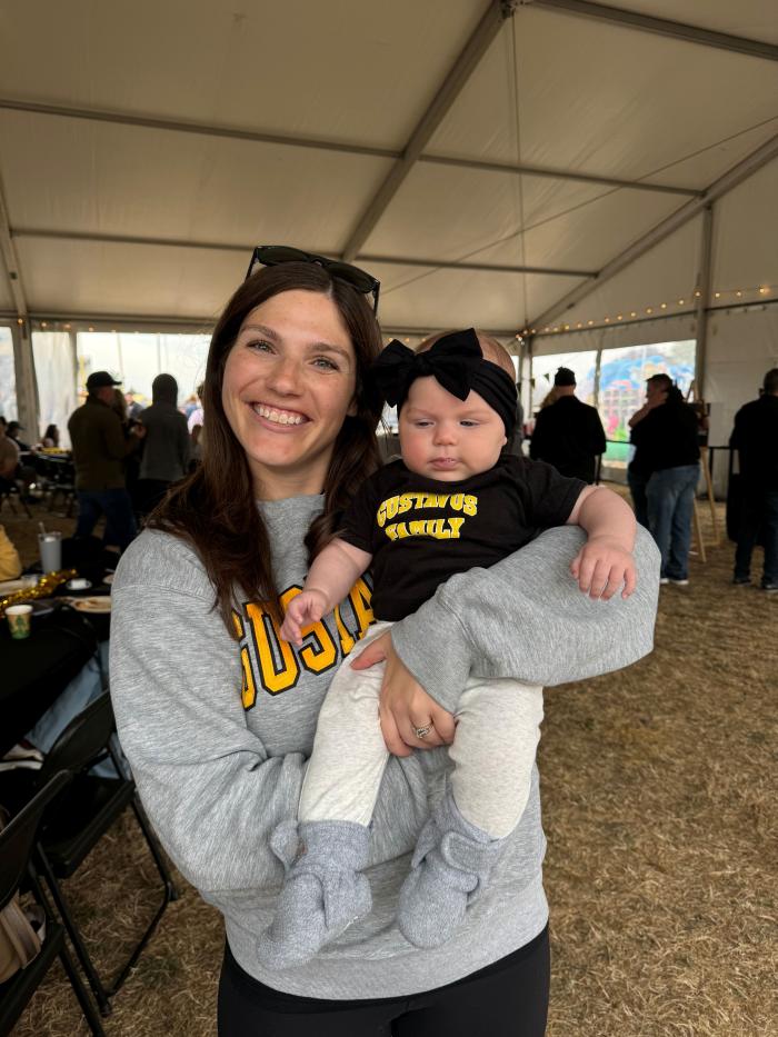 Young alumni with baby at Homecoming