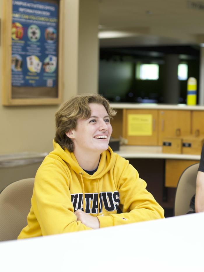 Two college students look intently as they answer someone's question. 