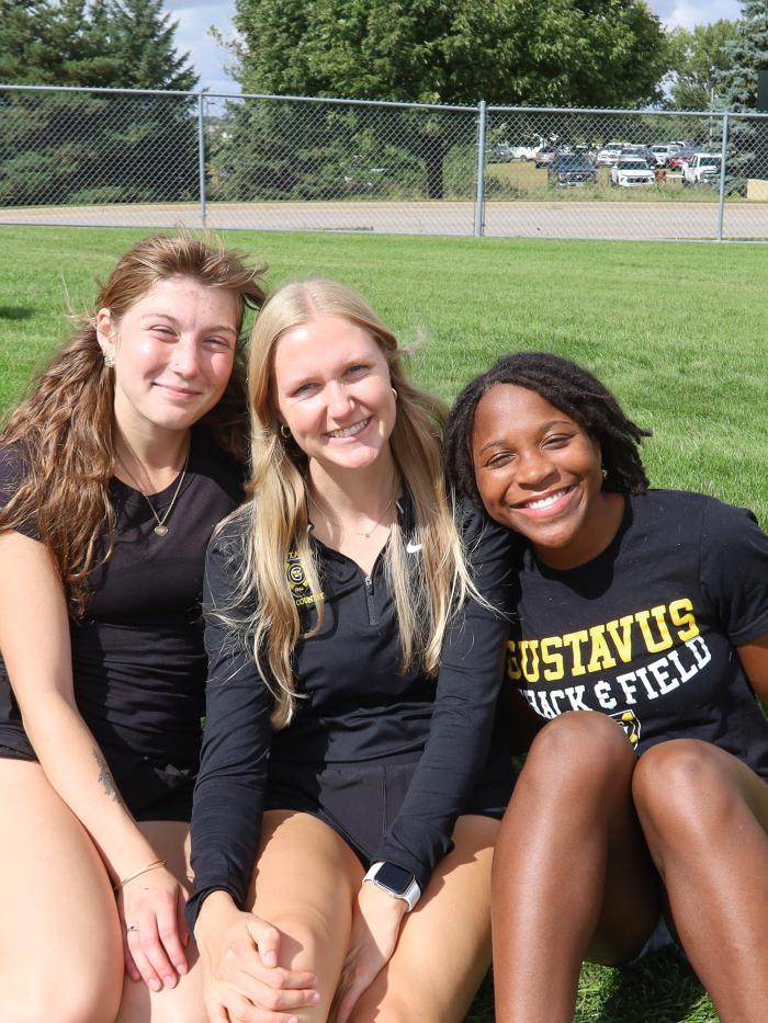 Three young ladies, sitting at sporting event