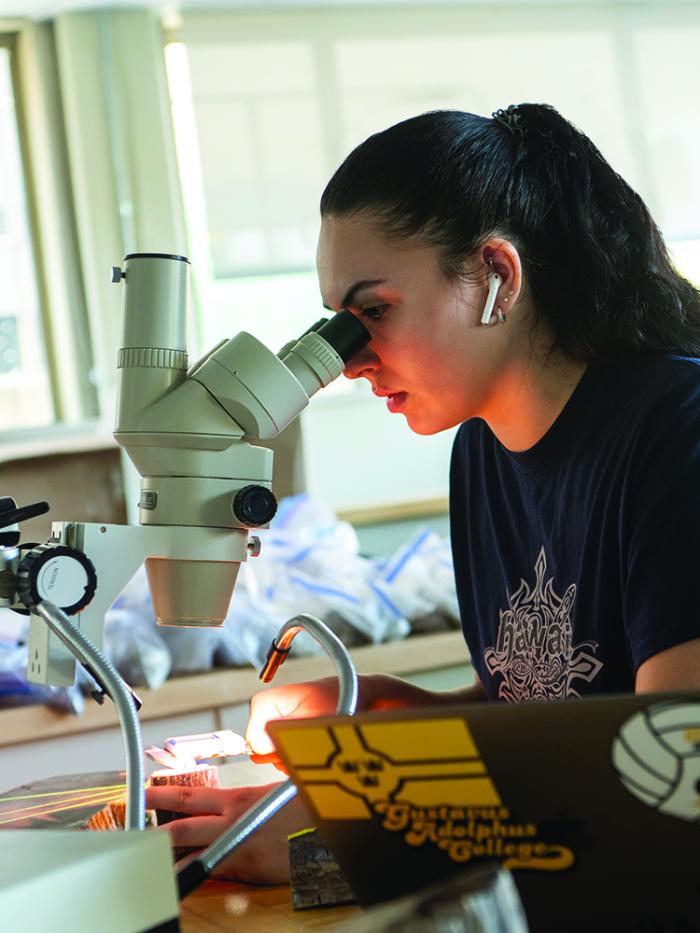 student in lab with microscope