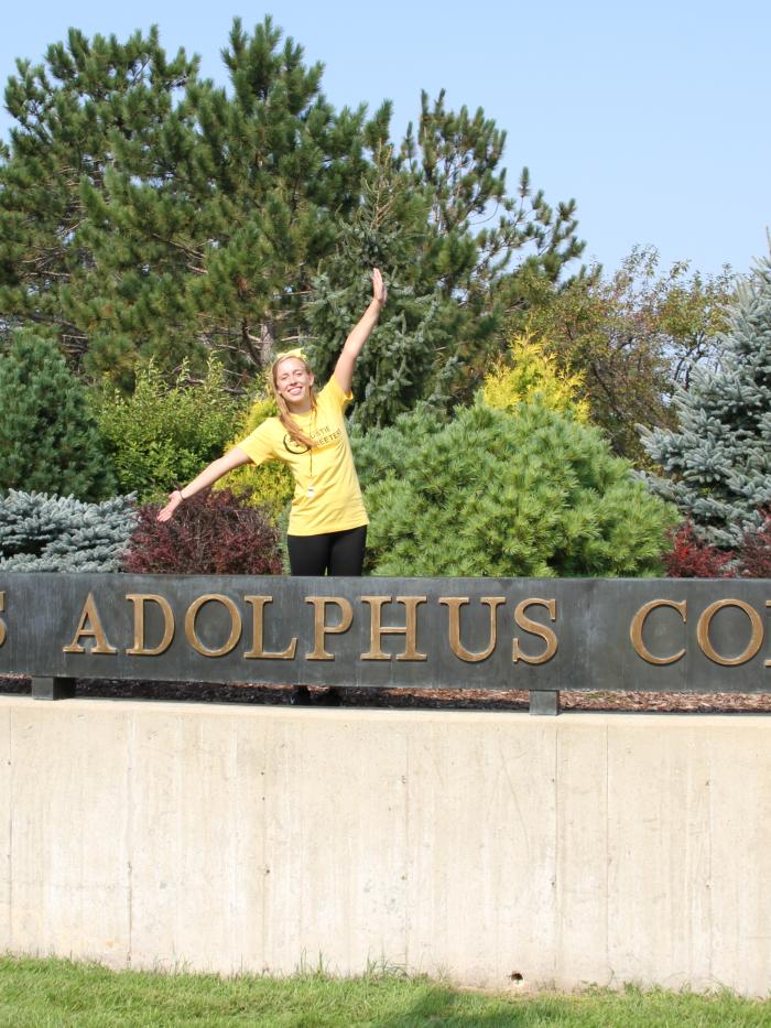 Gustie Greeter by college sign