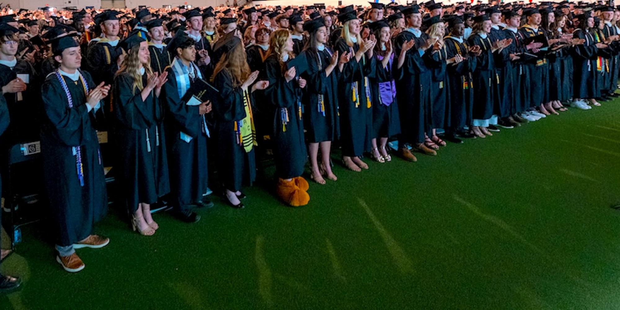 Gustavus Adolphus College students in caps and gowns wait to graduate. 